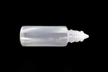 Plastic bottle of normal saline isolated on black background.