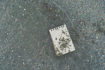 Small white notebook on sand at beautiful beach sea texture.