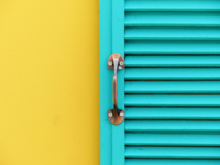 blue wood window on yellow wall