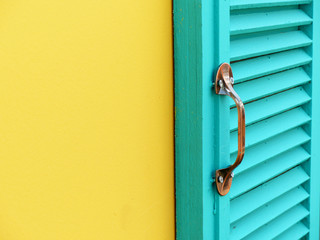 blue wood window on yellow wall