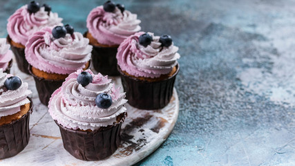 Food banner. Vanilla cupcakes with blueberry cream and berries. Close-up. Selective focus