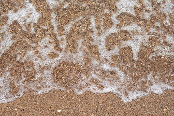 Beautiful soft waves of Blue Ocean with Sandy Beach Background close up. Sea sand wallpaper