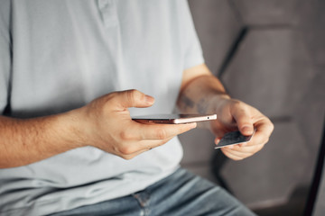 mobile payment and safe online transactions. digital finance and electronic operations. man holding credit card and phone.