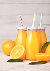 Fototapeta na wymiar Glass bottles of raw organic fresh orange juice