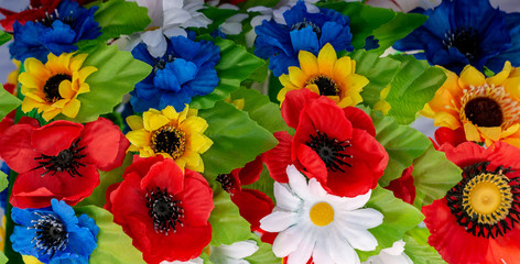arrangement bouquet poppies, daisies, sunflowers, green leaves closeup