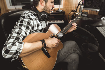 Man playing guitar in a recording studio. Concept guitarist composing music