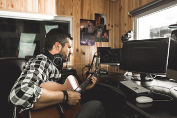Man playing guitar in a recording studio. Concept guitarist composing music