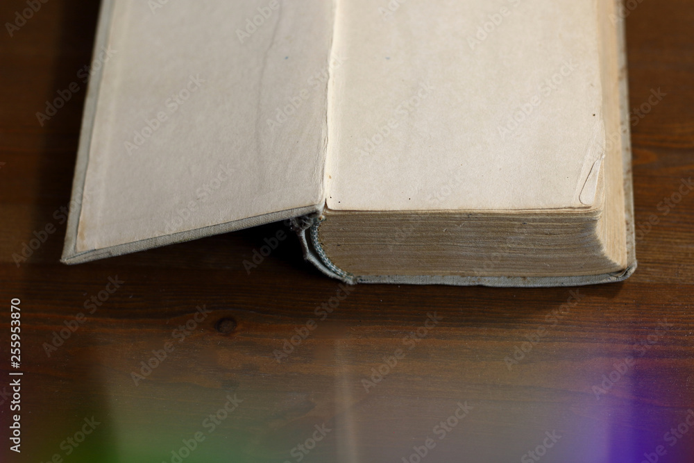 Fototapete An open old retro book with white blank empty pages on which the designer can write a greeting text or a postcard on the wooden background of the library atmosphere, book light of knowledge