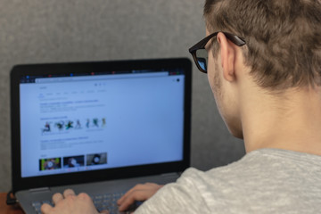 man with glasses working at a laptop at home. soft focus. home work concept