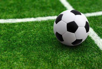 Soccer ball on green football field