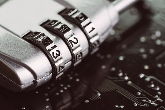 Digital cyber safety or security encryption concept, code numbers on combination pad lock on computer circuit board with solder, technology to encode online information or data protection