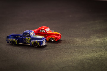 scale models of metal toy carts on a black background. colorful cars, different models and hot rods.