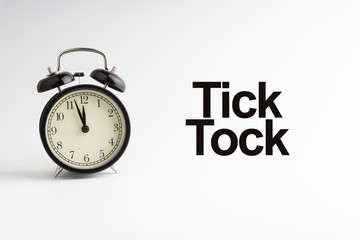 TICK TOCK inscription written and alarm clock on white background. Business and motivation concept