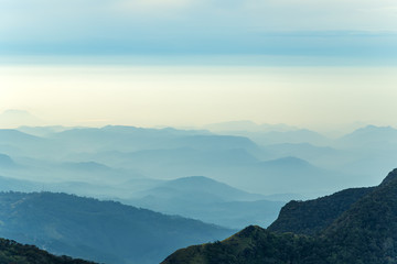 range with visible silhouettes sunrise cloud forest Worlds End in Horton Plains National Park Sri Lanka.