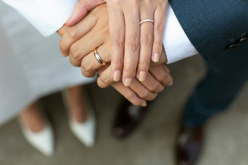 Bride and groom hold hands.