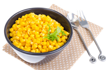 Canned corn in black bowl.