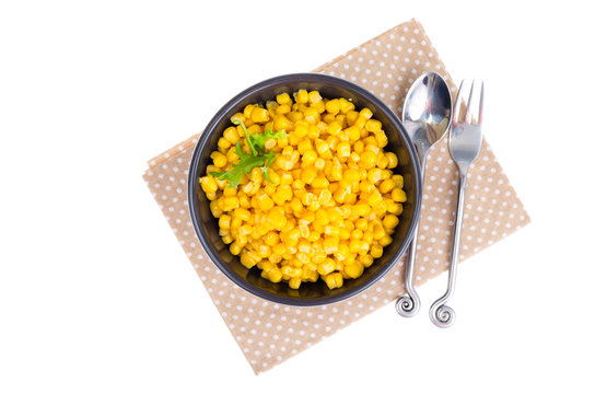 Canned corn in black bowl.