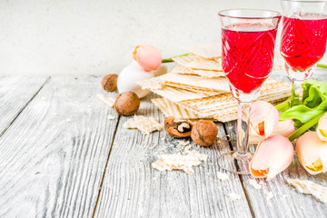 Pesah celebration concept. jewish Passover holiday background with matzo, eggs, spring flowers, wine, green background copy space top view