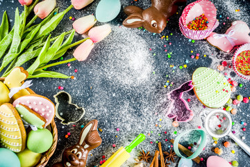 Easter greeting card background. Cooking gingerbread cookies ingredients, With colorful eggs. cookies and sugar sprinkles top view copy space