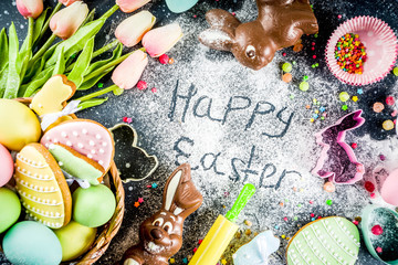 Easter greeting card background. Cooking gingerbread cookies ingredients, With colorful eggs. cookies and sugar sprinkles top view copy space