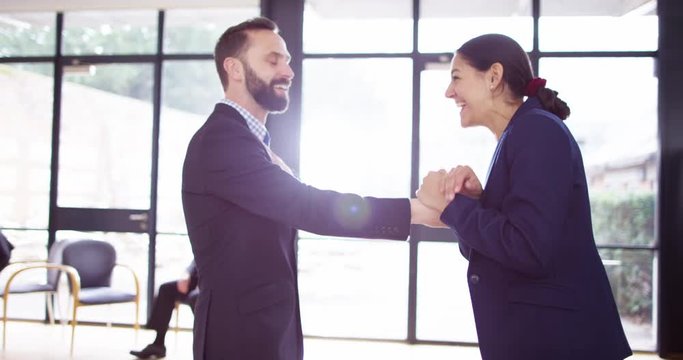 4K Socially awkward businessman attempts a high-five with colleague but misses