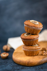 Homemade delicious muffin on dark background. Cup cakes with banana and walnut. Side view, copy space