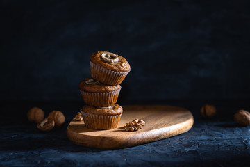 Homemade delicious muffin on dark background close-up. Cup cakes with banana and walnut. Side view,...