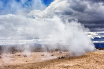 Namafjall Hverir geothermal area in Iceland. Stunning landscape of sulfur valley with smoking fumaroles and blue cloudy sky, travel background, tourist attraction
