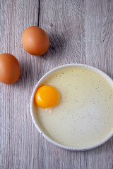 Eggs and yolk on a wooden board background