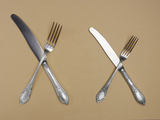 Cupronickel knives and forks on a yellow background with copyspace