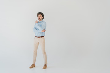 Fototapeta na wymiar handsome smiling man in blue shirt and beige jeans isolated on grey