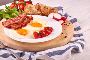 fried eggs with cherry tomatoes on the grill with bread