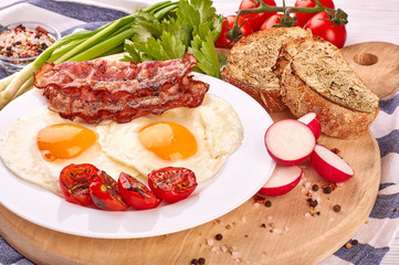 fried eggs with cherry tomatoes on the grill with bread