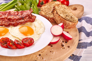fried eggs with cherry tomatoes on the grill with bread