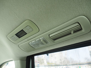 Interior lights in the car with air conditioning grille. air conditioning control panel. Gray velor...