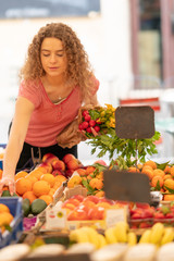 Young woman shopping for fruits and vegetables at the market