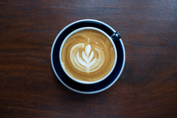 Top view of Latte art on the wood table background.