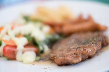 Soft focus of pork steak on dish.