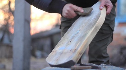 man brushes the board clean with a metal brush