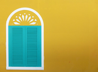 blue wood window on yellow wall