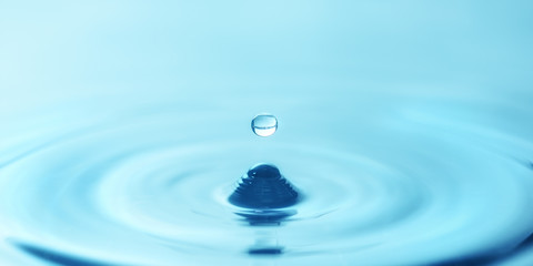 a drop of water close-up drips into the water, forming circles
