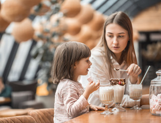 Happy young women mother with children drinking a milkshake