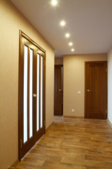 Light from a doorway with close wood doors an interior of appartments