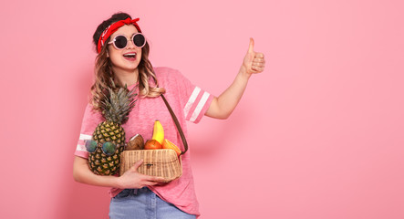 Portrait of a girl with healthy food, fruits, on a pink background