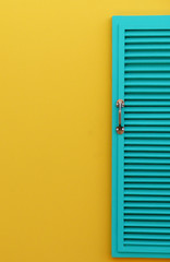blue wood window on yellow wall