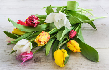 Obraz premium bouquet of colorful tulips on a white wooden floor