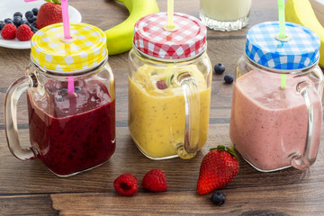 Various fruit and berry smoothies in glass jars