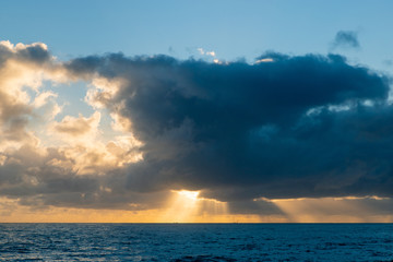 Fototapeta na wymiar Ray of light through clouds above the ocean.