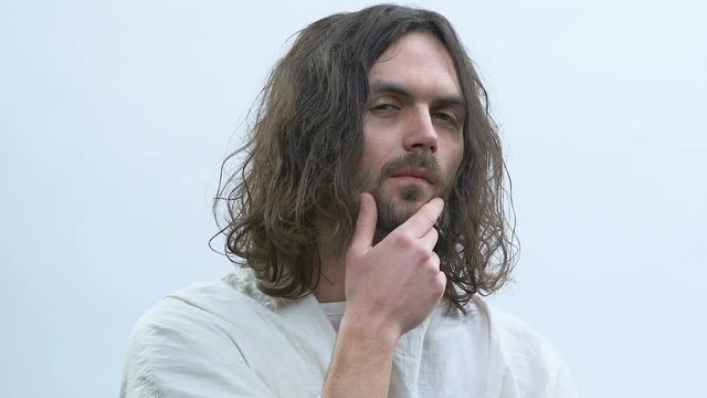 Jesus touching chin against white background, thinking about saving sinners