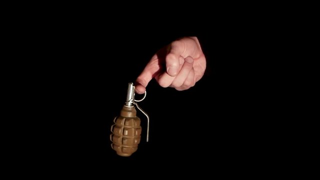 man holds a grenade in his hand for a ring on a black background close-up